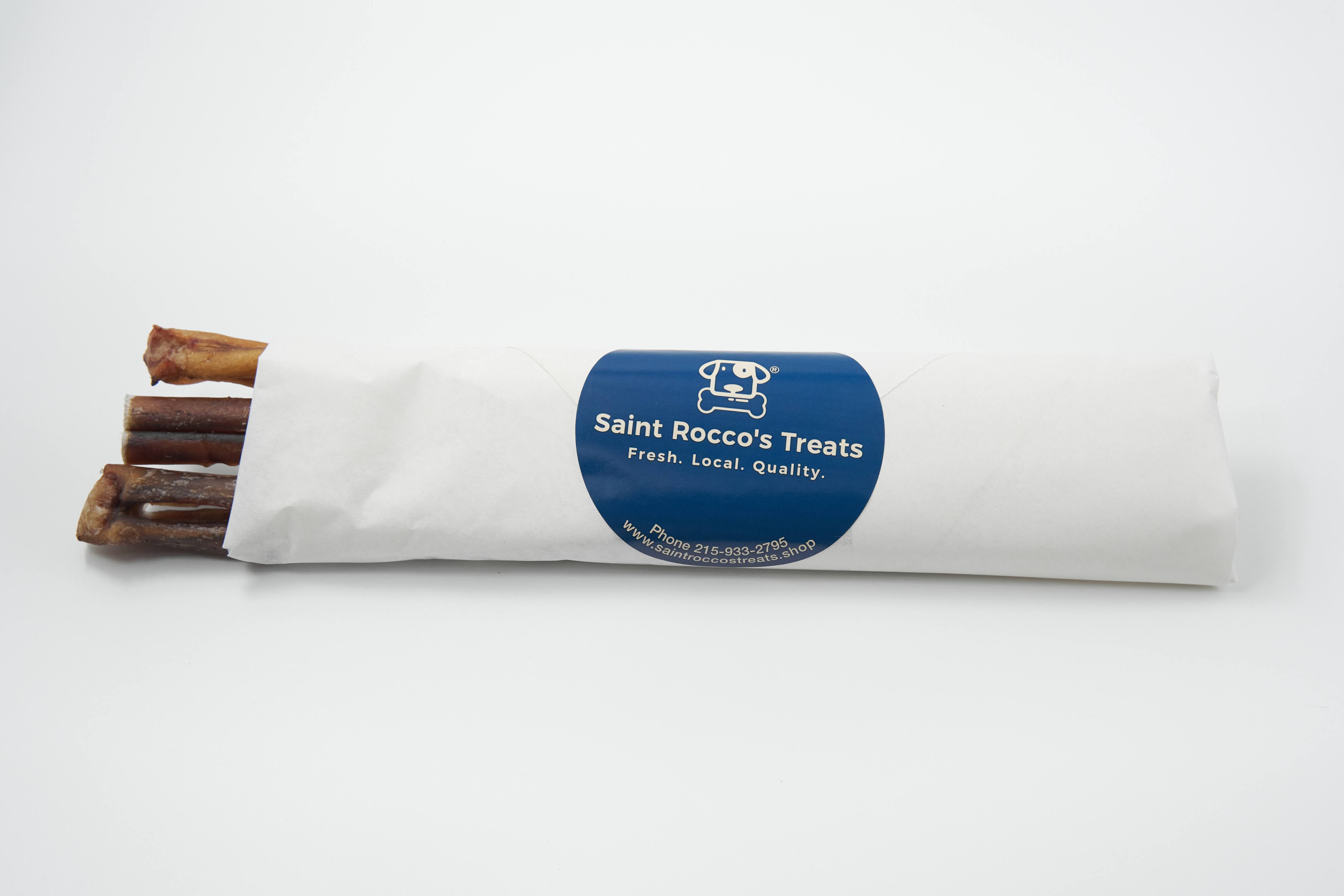 A white paper package labeled Saint Rocco's Treats holds four all-natural Saint Rocco's Bully Sticks, with a blue sticker reading "Fresh. Local. Quality." displayed on a plain white background.