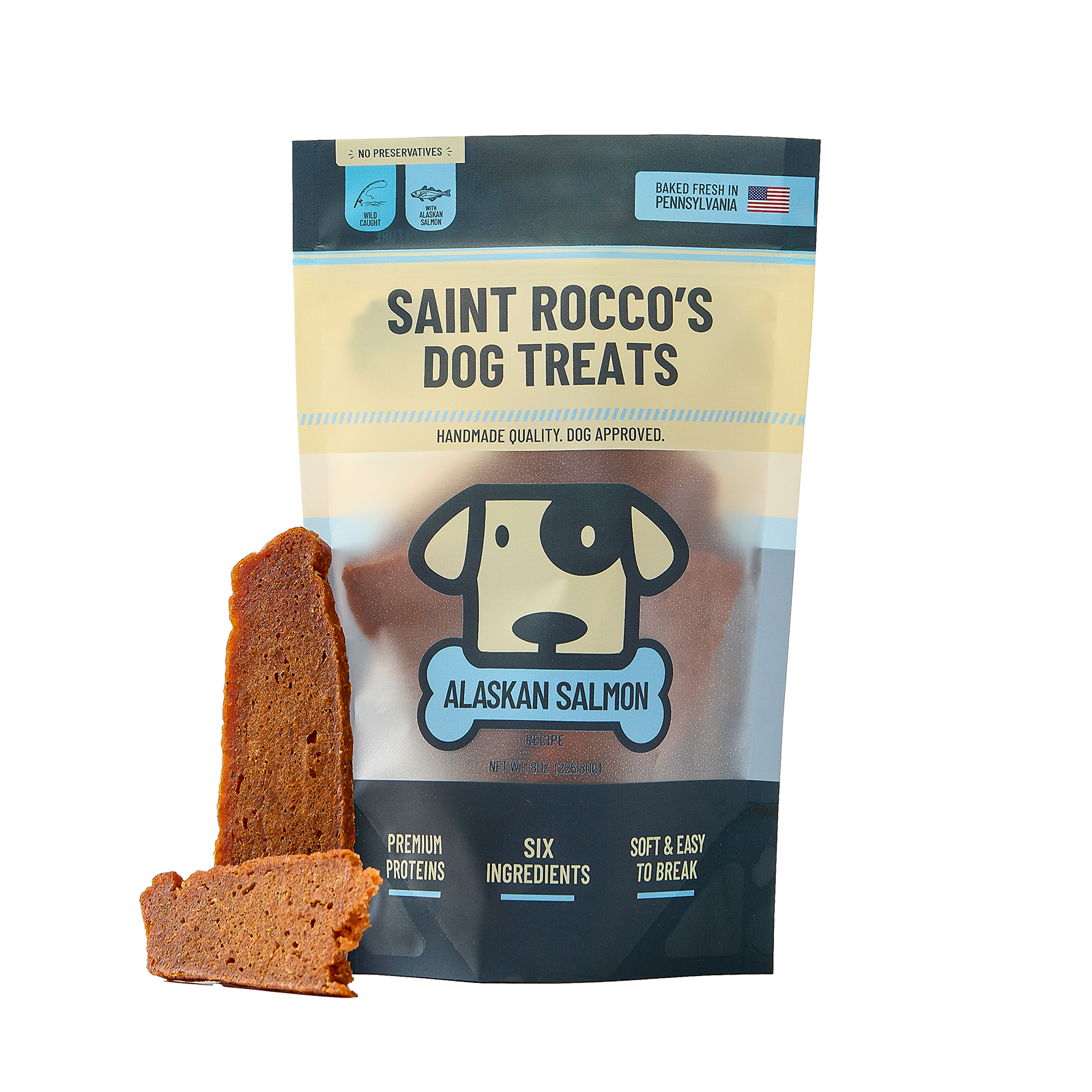 A bag of Saint Rocco's Dog Treats Alaskan Salmon flavor, shown with two pieces of the brown dog treat displayed in front on a white background.