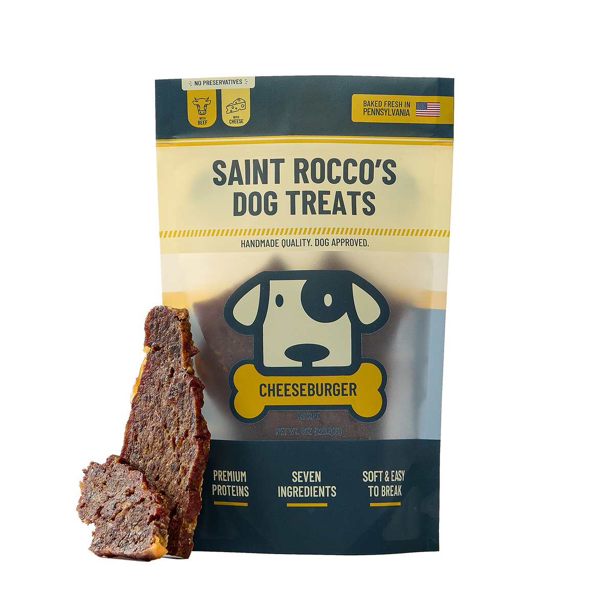 A bag of Saint Rocco's Dog Treats Cheeseburger flavor shown on a white background, with two slices of the dark brown meat treat leaning against the bag.