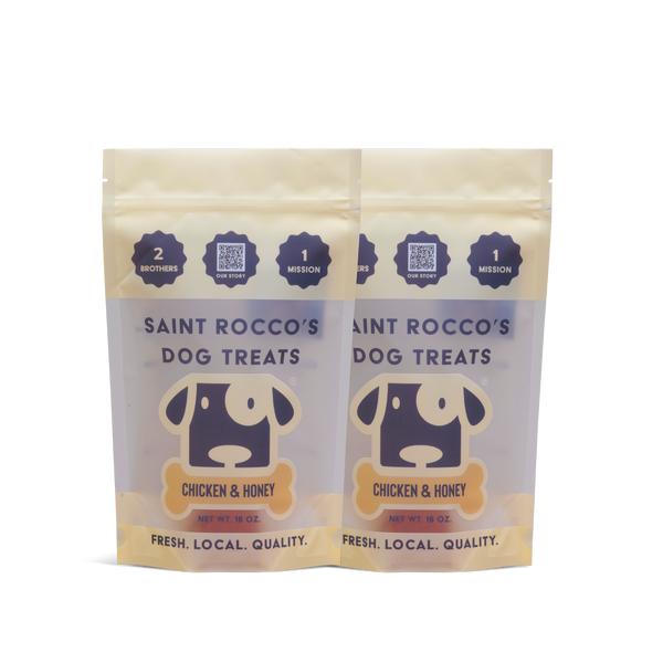 Two packages of Saint Rocco's Dog Treats with chicken and honey flavor on a white background.