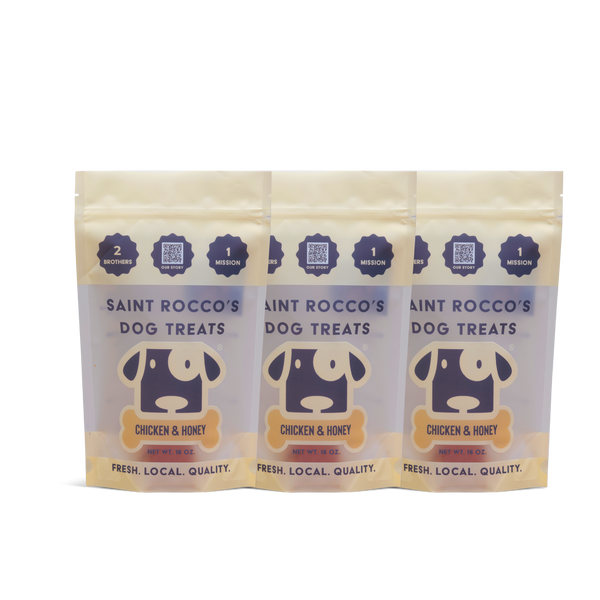 Three packages of Saint Rocco's Dog Treats with chicken and honey flavor on a white background.