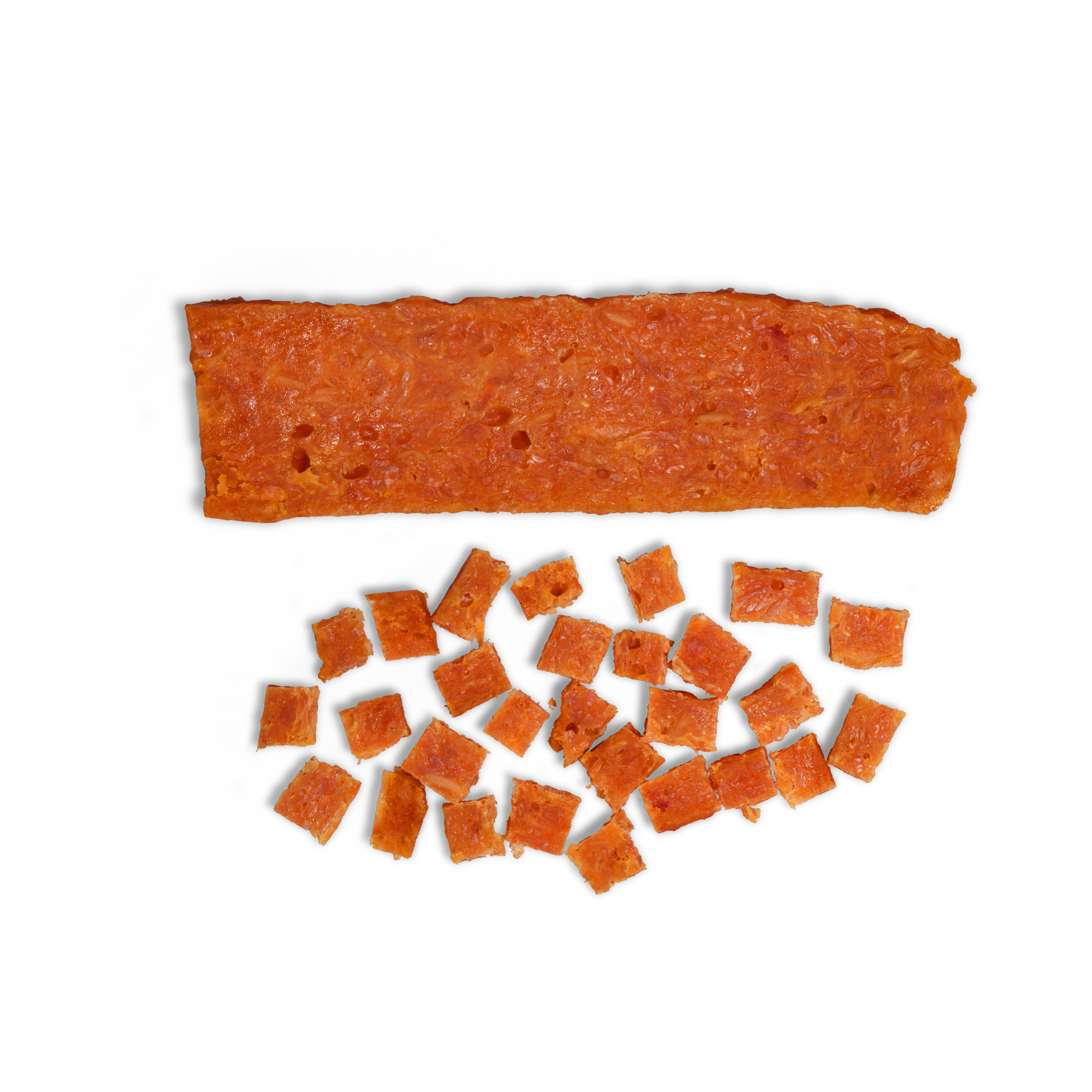 A rectangular slice of Saint Rocco's Treats Chicken and Honey Treats sits above several small, evenly cut squares—all arranged on white, resembling artisan dog treats perfect for high-value training sessions.