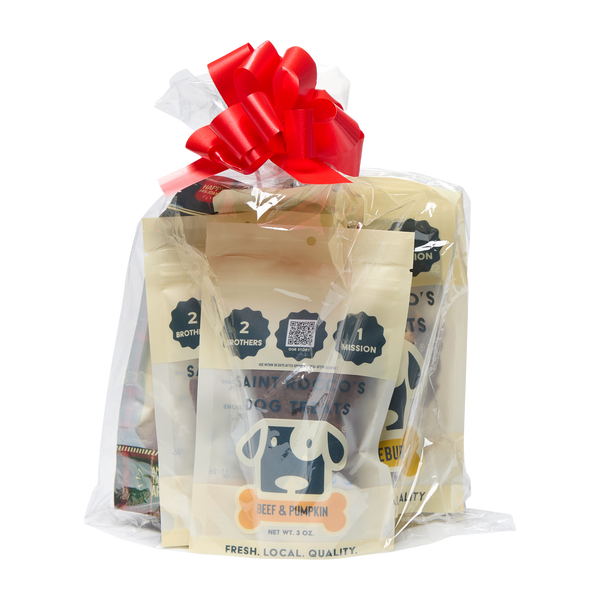 Saint Rocco's Treats Stocking Stuffer features hand-crafted, beef & pumpkin dog treats with a cartoon dog face, clear wrapping, and a festive red bow—an ideal holiday gift from Saint Rocco's Treats your pup will love!.