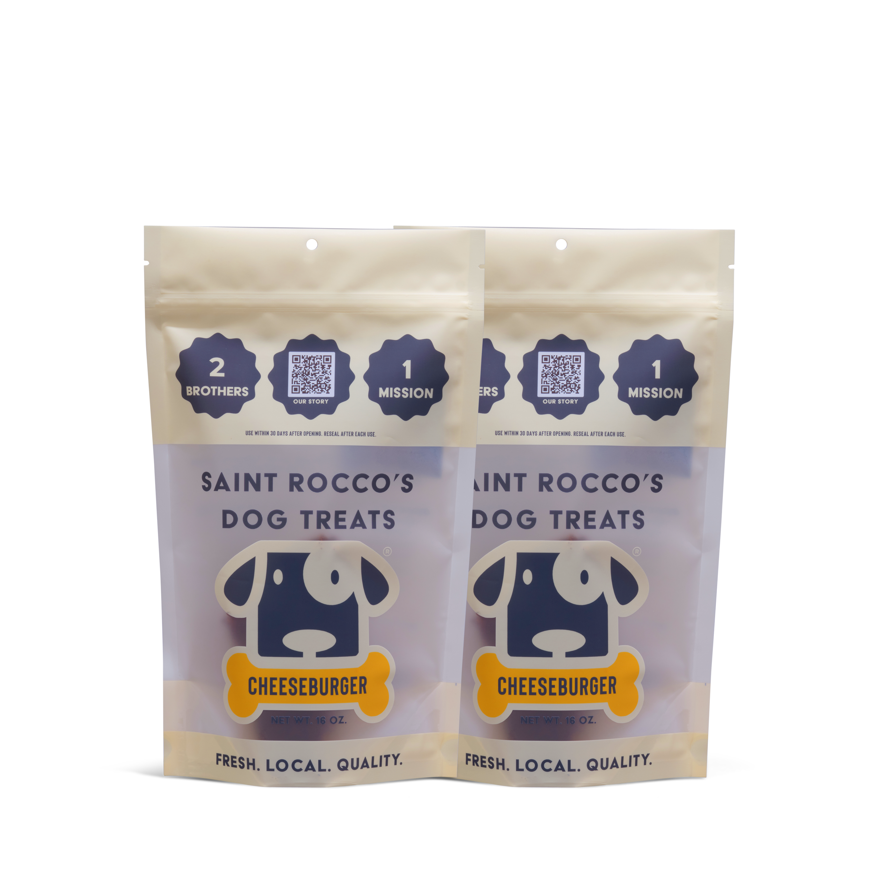 Two resealable bags of Saint Rocco's Treats Cheeseburger Treats, featuring a blue and white dog illustration and text emphasizing freshness, local sourcing, and the brand’s mission.