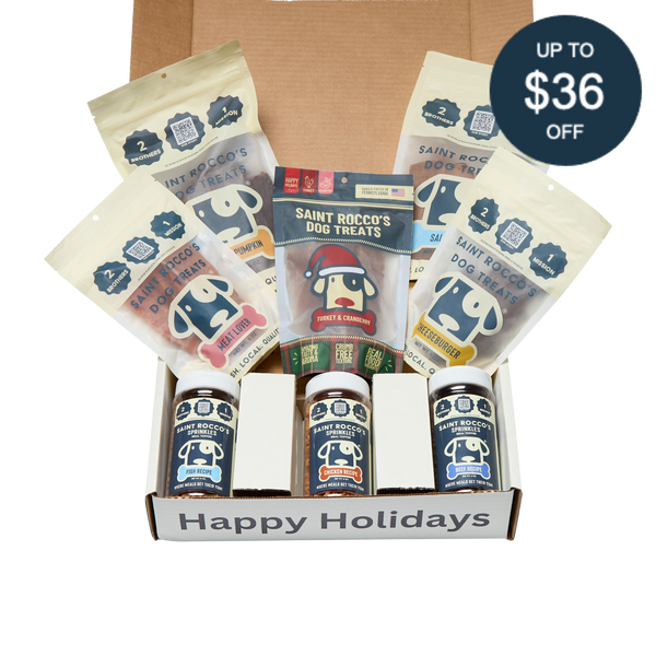 Saint Rocco's Naughty or Nice Box by Saint Rocco's Treats includes hand-crafted dog treats in treat bags, packs, and jars. The gift box features a "Happy Holidays" label and a circular sticker noting up to $36 off.