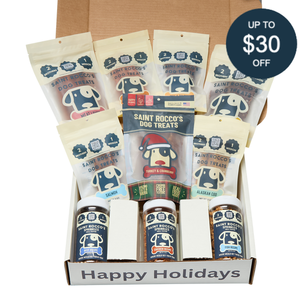 An open Saint Rocco's Naughty or Nice Box by Saint Rocco's Treats is filled with gourmet dog treats, featuring a "Happy Holidays" label and a circular tag in the corner that says "Up to $30 off.