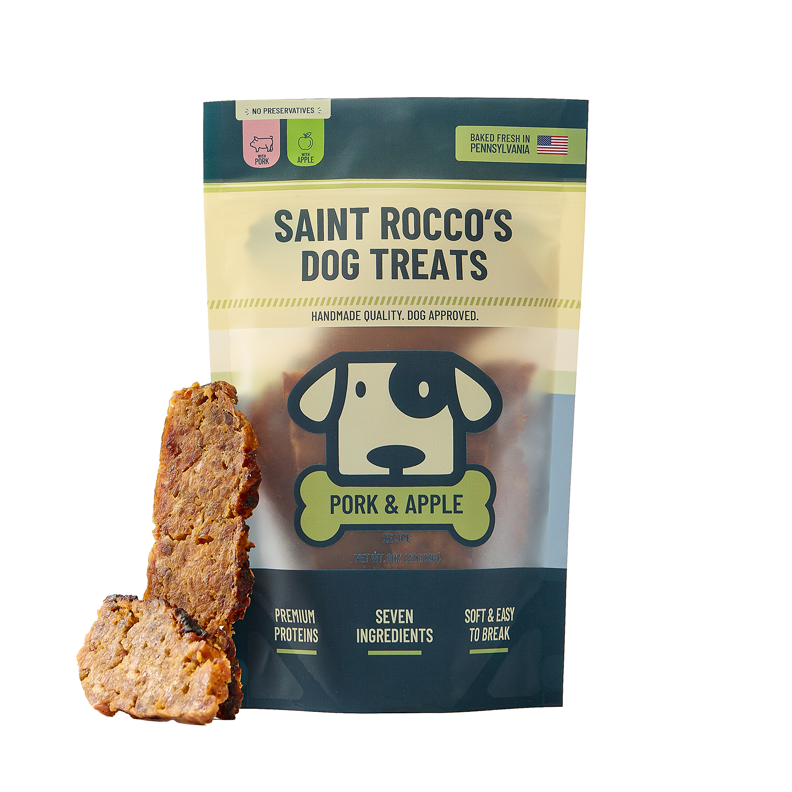 A bag of Saint Rocco's Dog Treats Pork & Apple flavor stands on a white background with two dog treats displayed in front.