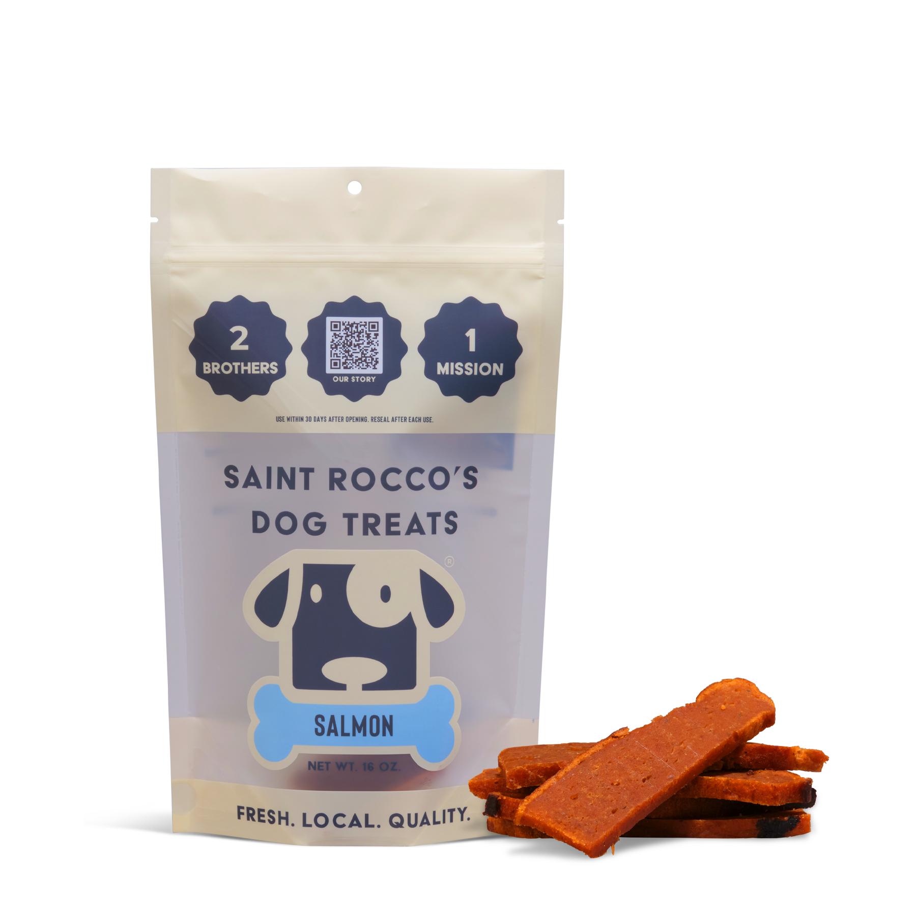 A bag of Saint Rocco's Treats Alaskan Salmon Treats stands upright beside several salmon-colored strips. The packaging displays a cartoon dog face and highlights freshness, quality, and local sourcing.