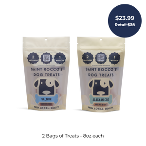 Saint Rocco's Treats Seafood Sampler Bundle: two 8oz bags of artisan dog treats—Salmon and Alaskan Cod flavors. Blue tag: $23.99 Retail $28. Text below: 2 Bags of Treats - 8oz each. Perfect seafood treats for your pup!.