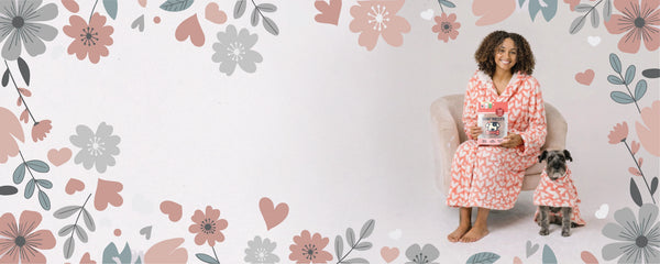 Woman in a pink floral robe sitting on a chair with a dog, surrounded by floral patterns.
