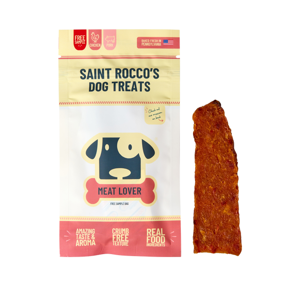 A bag of Saint Rocco's Treats labeled "Sample Treat" sits beside a reddish-brown chew. The packaging, featuring a cartoon dog, highlights real food ingredients and various flavors such as chicken, beef, and salmon.