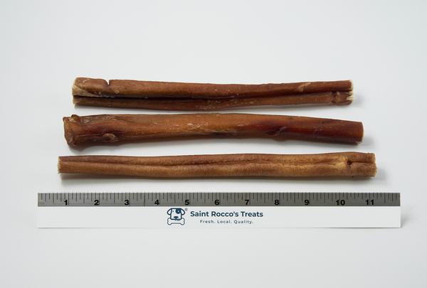 Three Bully sticks of different lengths on a white background with a ruler for scale, branded 'Saint Rocco's Treats'.